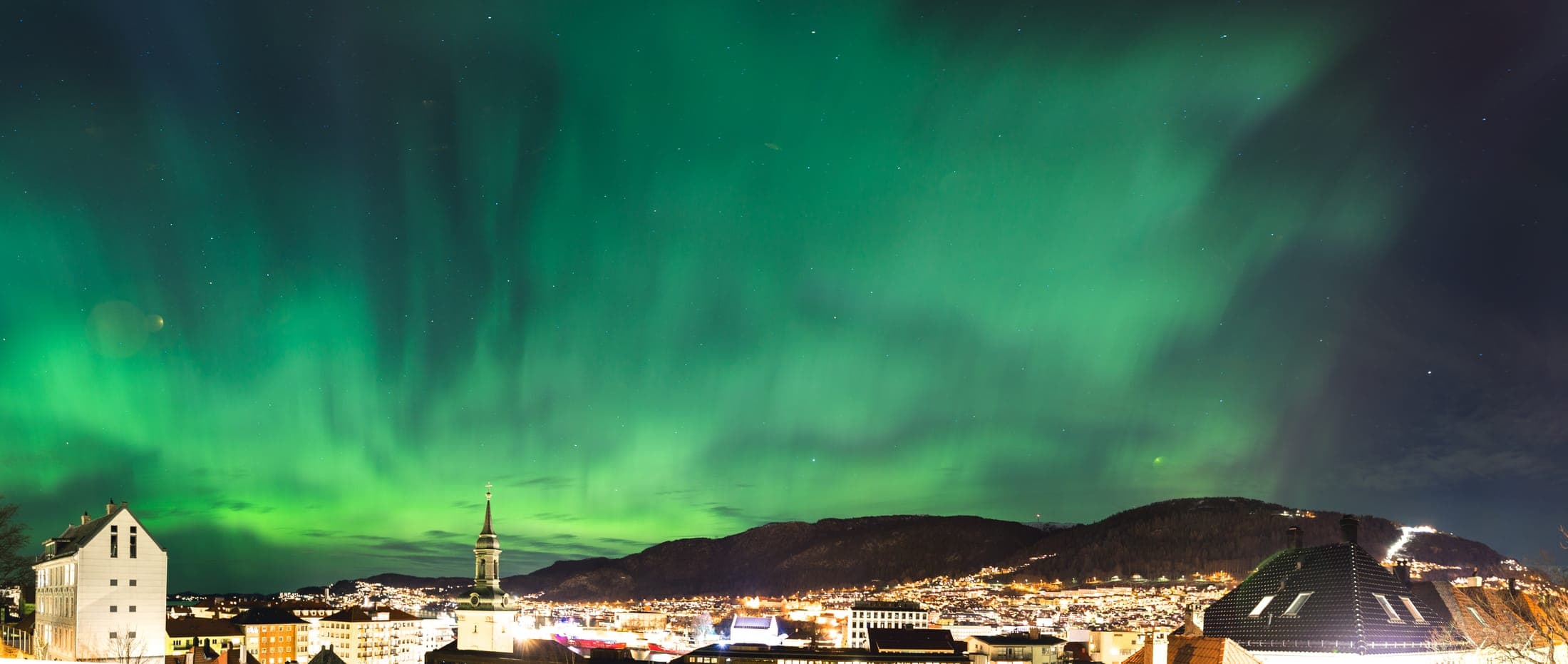 Green aurora borealis (Northern Lights) glowing over Bergen, Norway