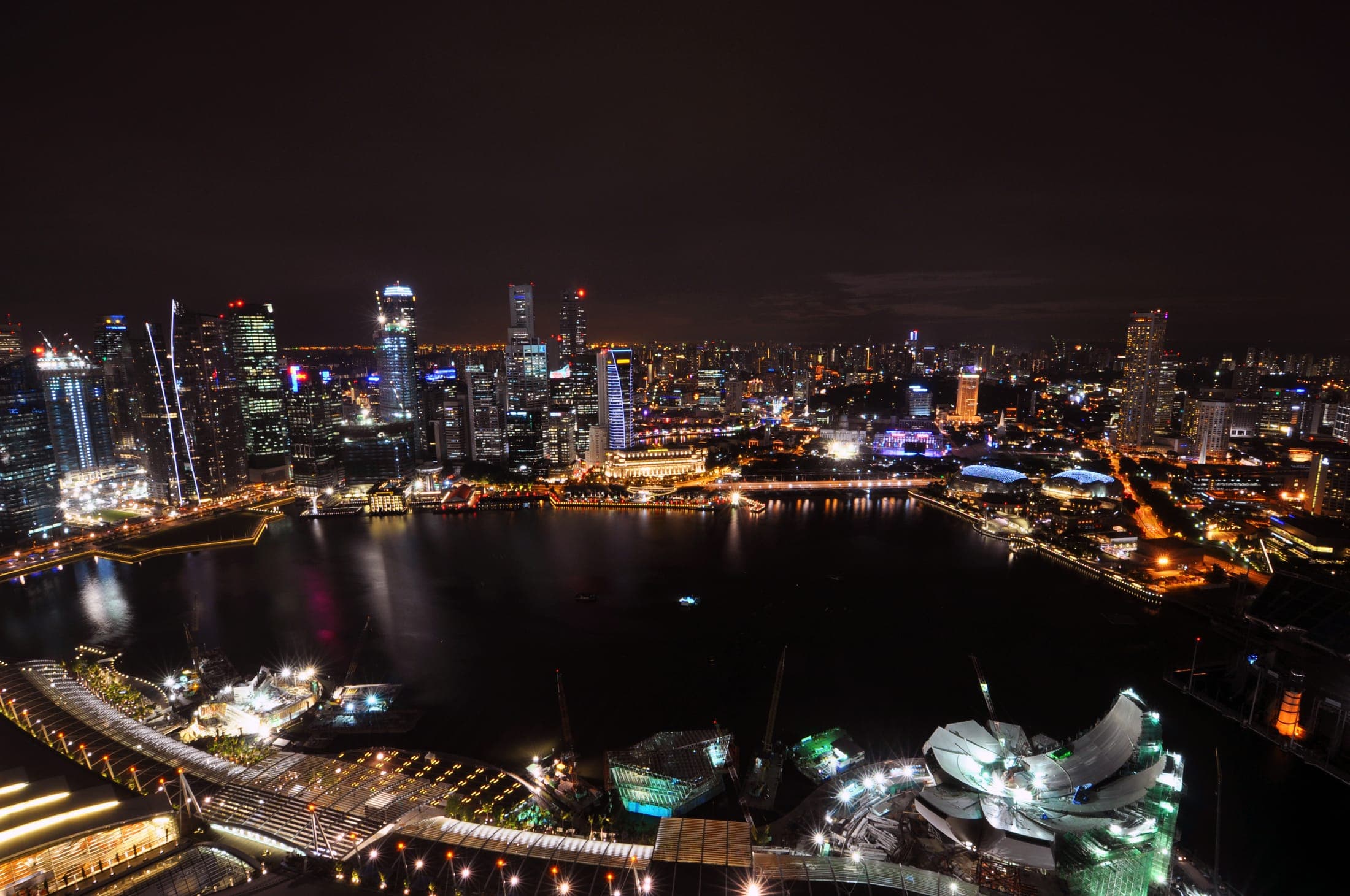 Marina Bay Sands hotel towers with SkyPark and Singapore CBD skyline at night