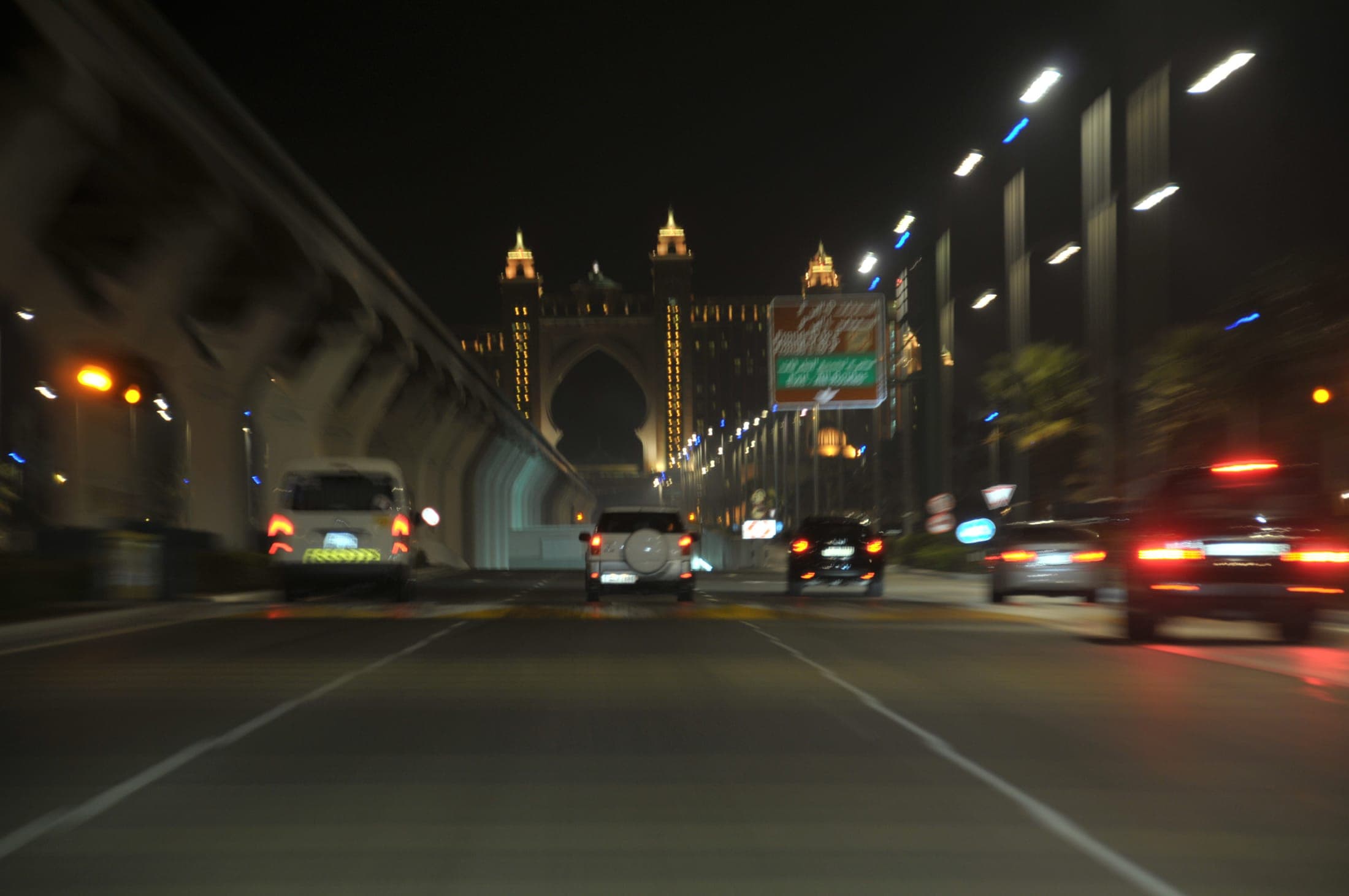 Atlantis The Palm resort hotel at dusk, its arch and golden facade lit at the apex of Palm Jumeirah