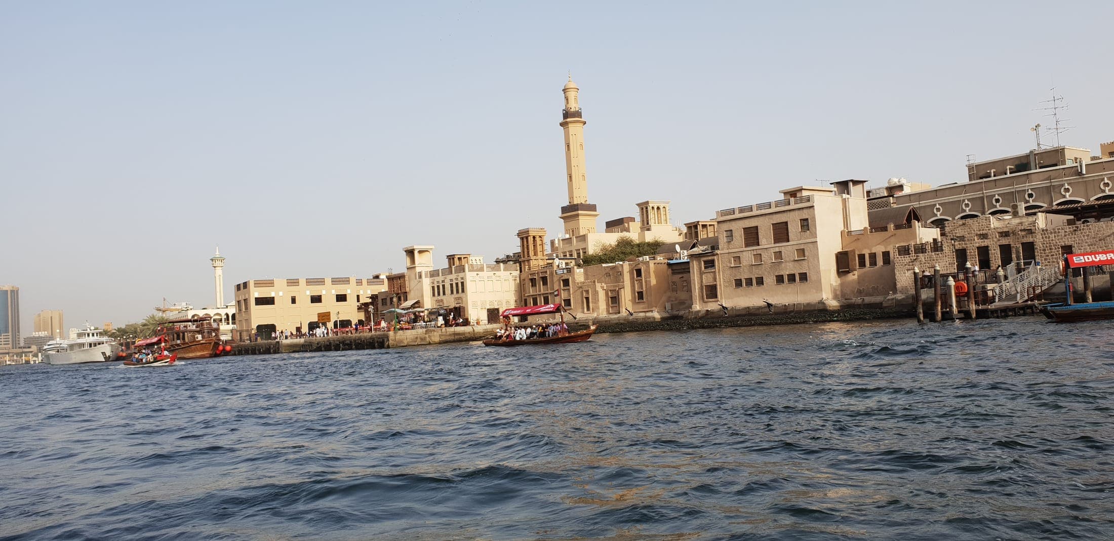 View of Old Dubai Creek and traditional dhow harbor, seen from a wooden dhow boat