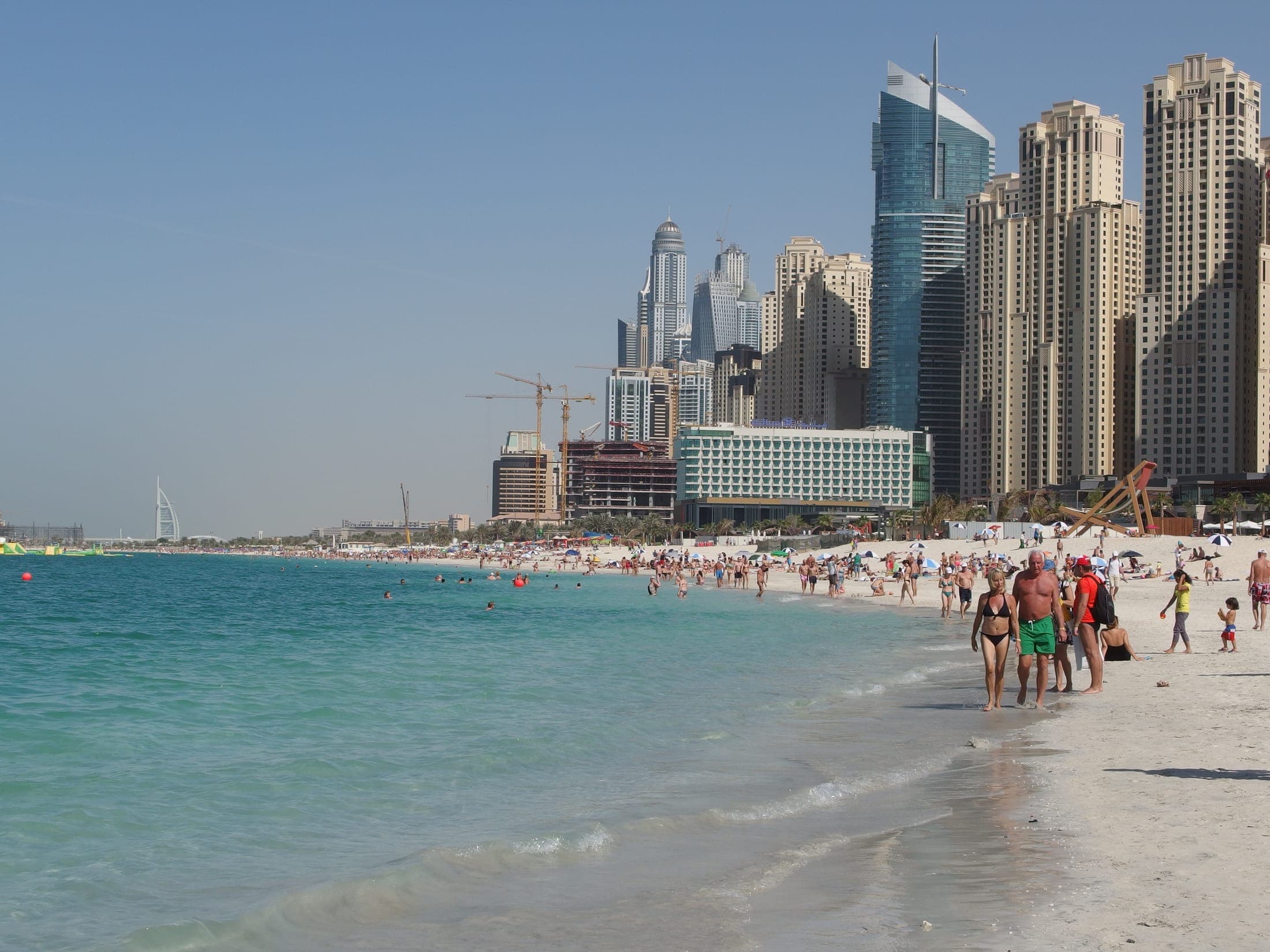 Sandy beach scene at Jumeirah Beach Residence with Dubai Marina towers in the background