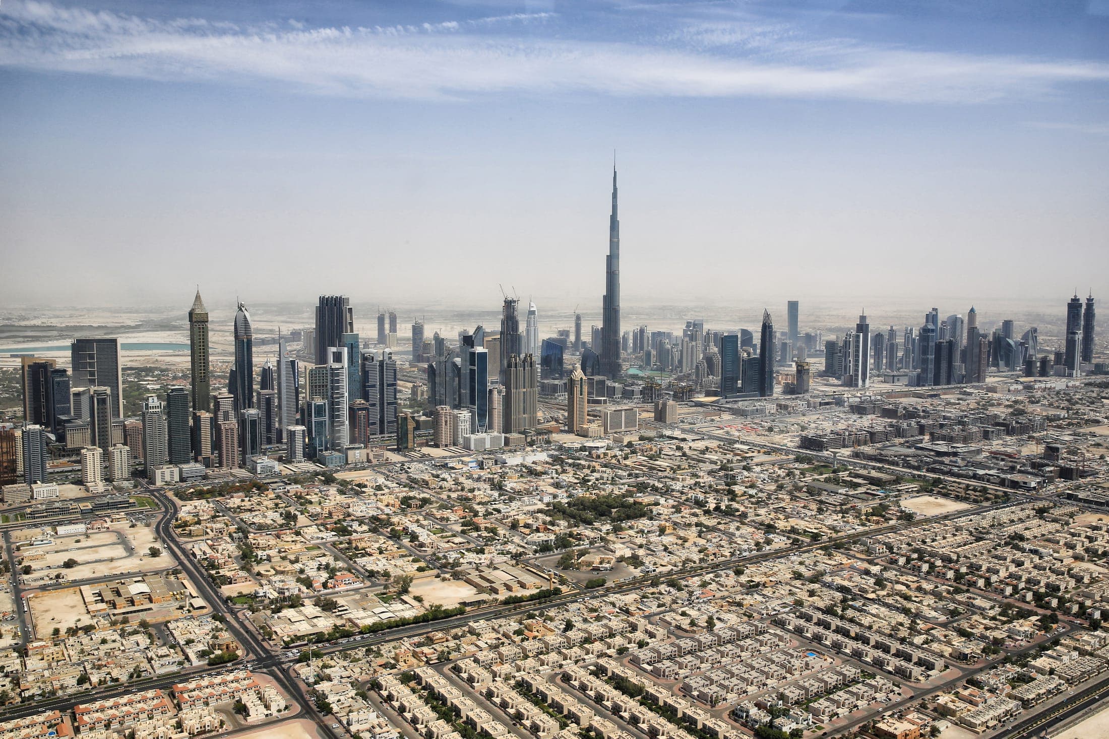Wide daytime view of the Dubai skyline with Burj Khalifa towering above the city