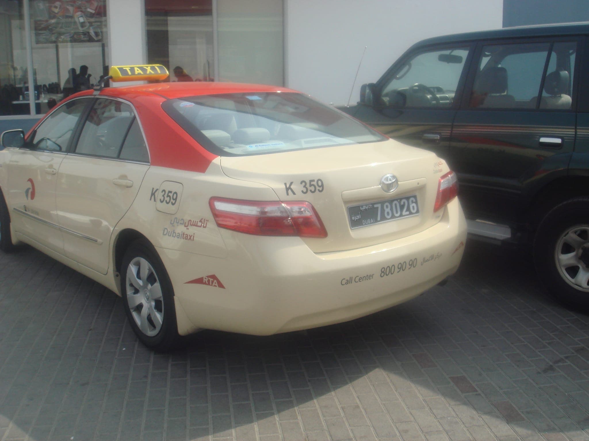 Cream-colored Dubai taxi sedan parked on a city street